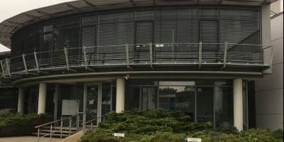 Modernes Bürogebäude aus Glas und Stahl an neuen Eigentümer übergeben